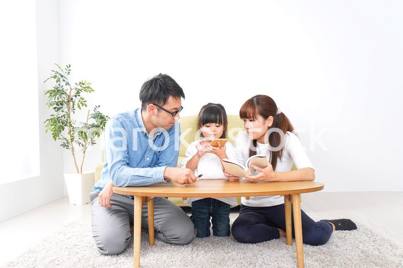 子どもに教育をする両親