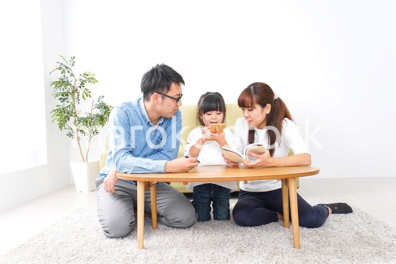 子どもに教育をする両親