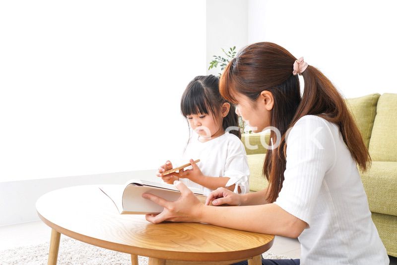 子どもに教育をする両親