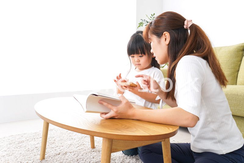 子どもに教育をする両親