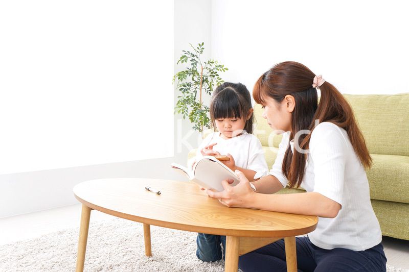 子どもに教育をする両親