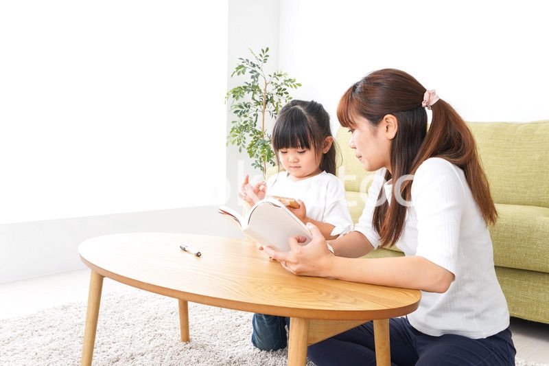 子どもに教育をする両親