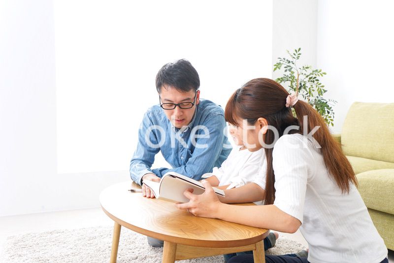 子どもに教育をする両親