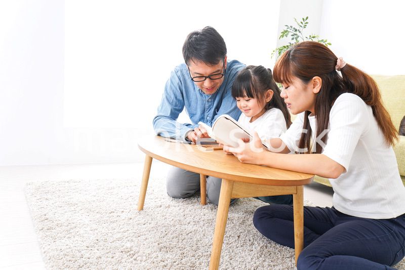 子どもに教育をする両親