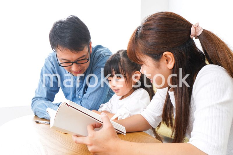 子どもに教育をする両親
