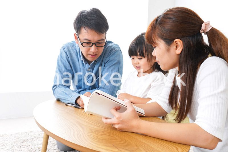 子どもに教育をする両親