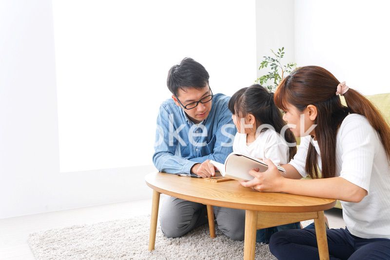 子どもに教育をする両親