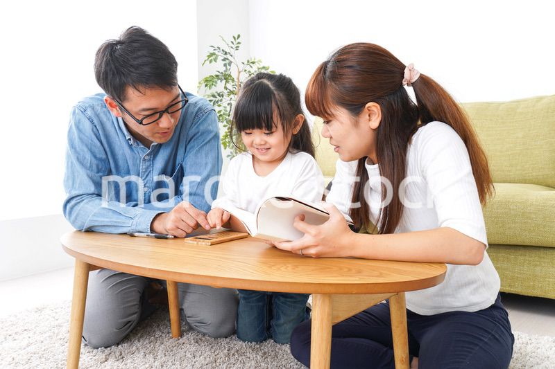 子どもに教育をする両親