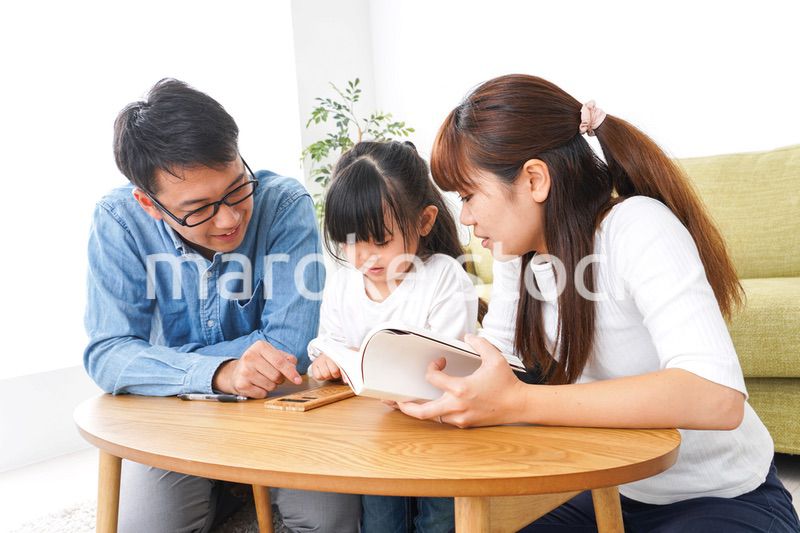 子どもに教育をする両親