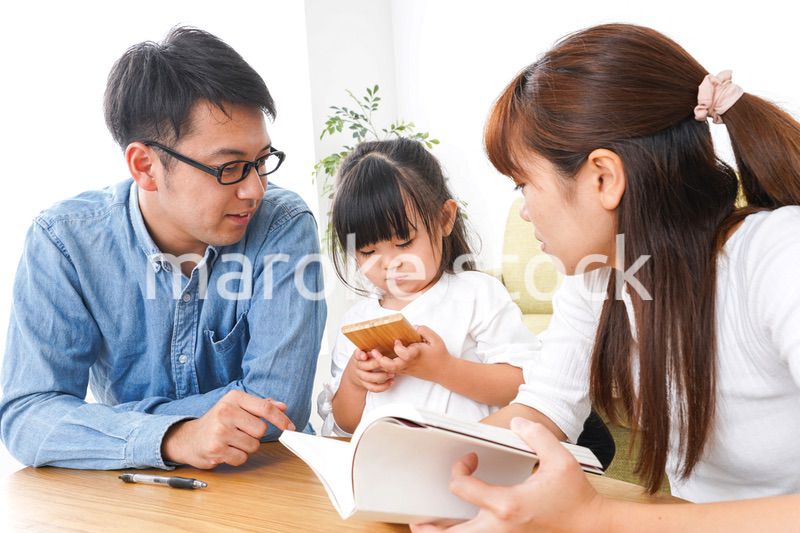 子どもに教育をする両親