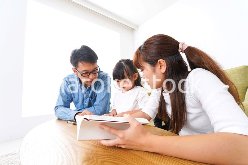 子どもに教育をする両親
