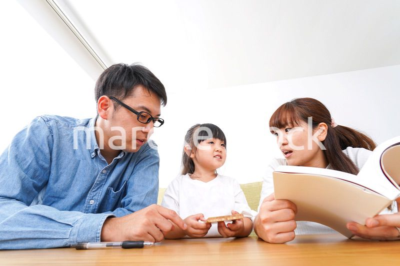 子どもに教育をする両親
