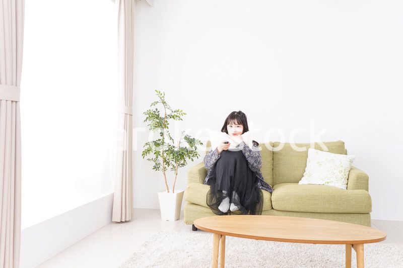 家でテレビを見る若い女性