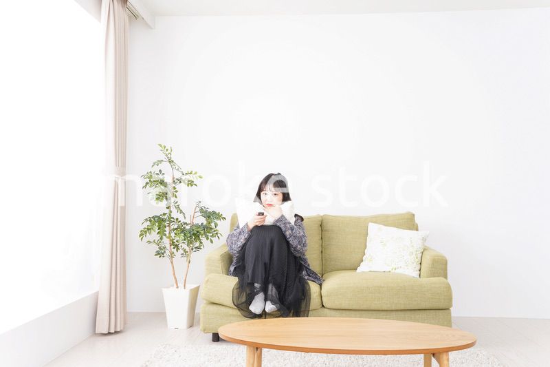 家でテレビを見る若い女性