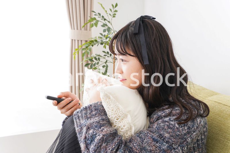 家でテレビを見る若い女性