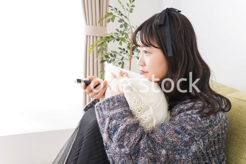 家でテレビを見る若い女性