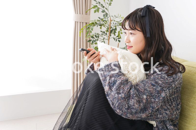 家でテレビを見る若い女性