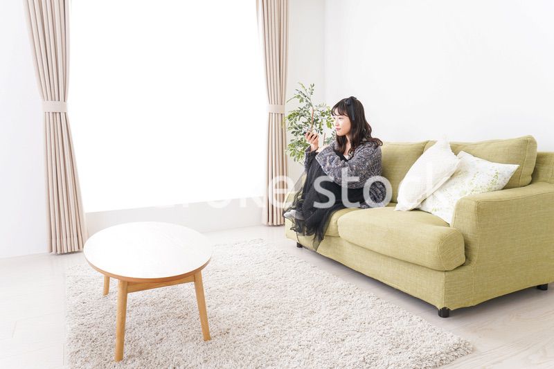 家でテレビを見る若い女性