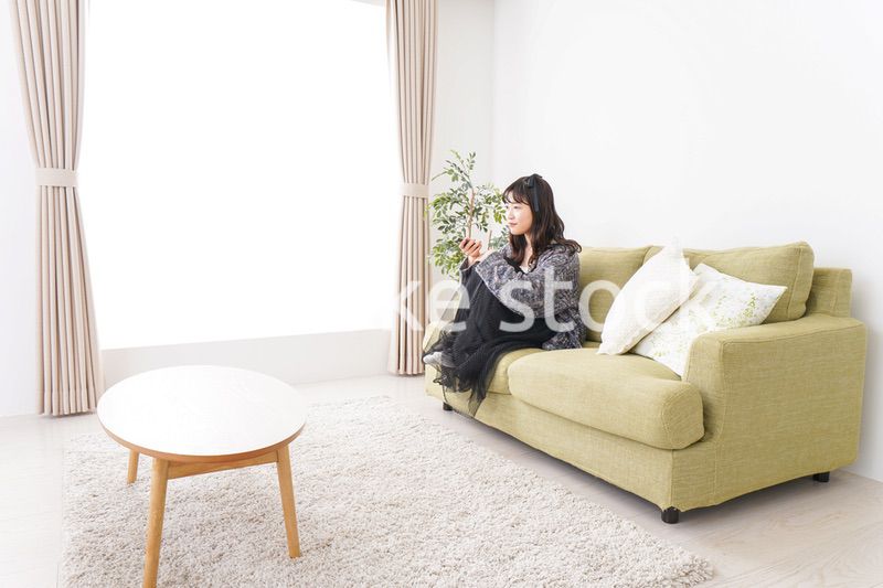 家でテレビを見る若い女性