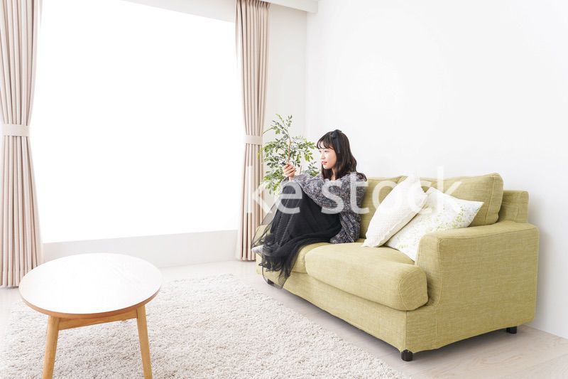 家でテレビを見る若い女性