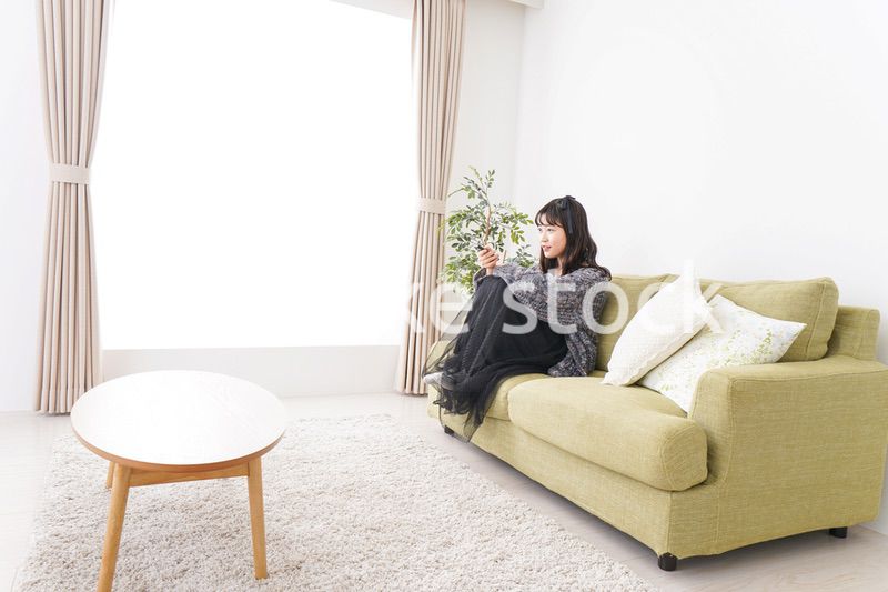 家でテレビを見る若い女性