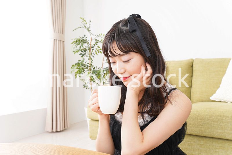 家でコーヒーを飲む女性
