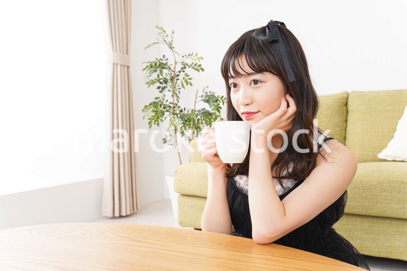 家でコーヒーを飲む女性