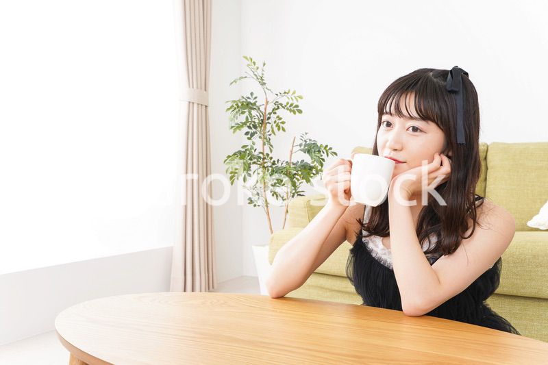 家でコーヒーを飲む女性