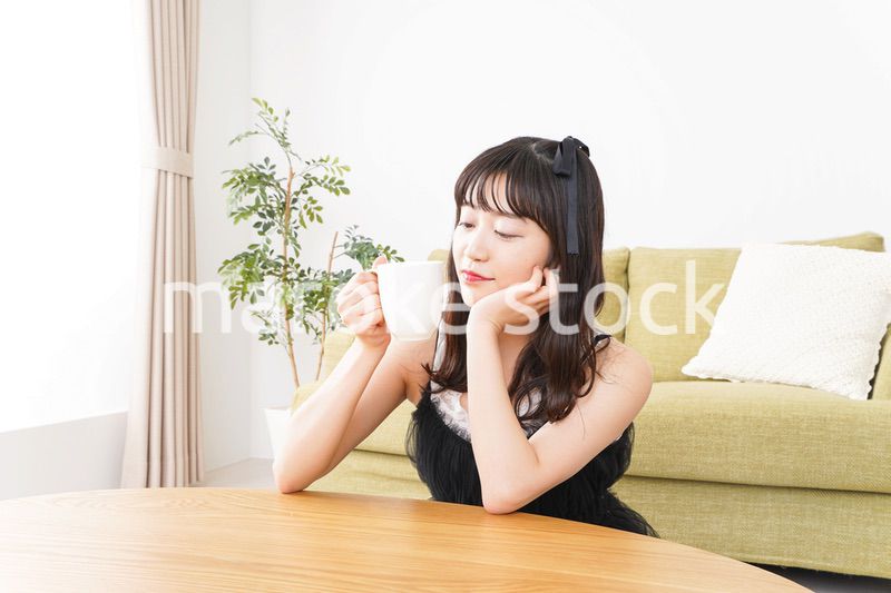 家でコーヒーを飲む女性