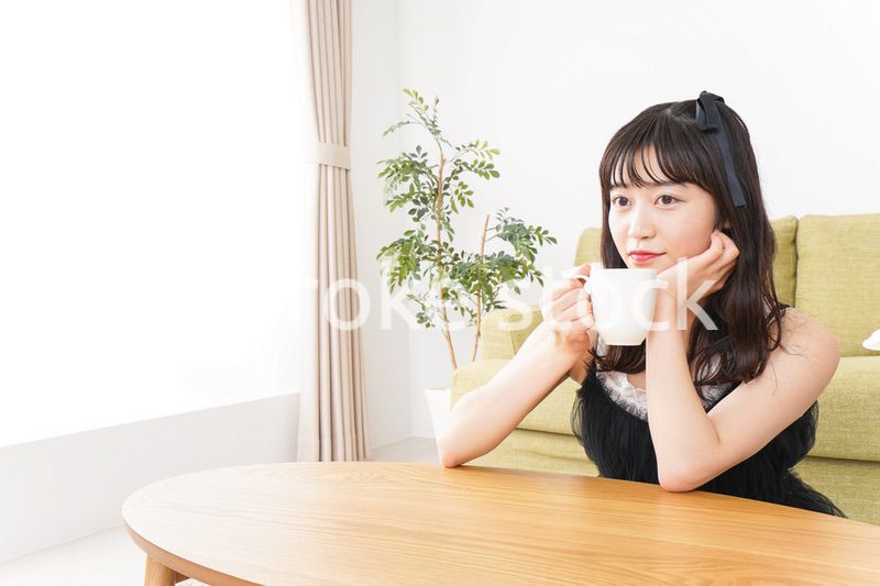 家でコーヒーを飲む女性