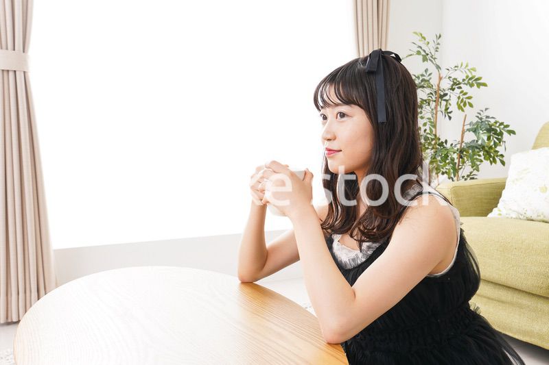 家でコーヒーを飲む女性