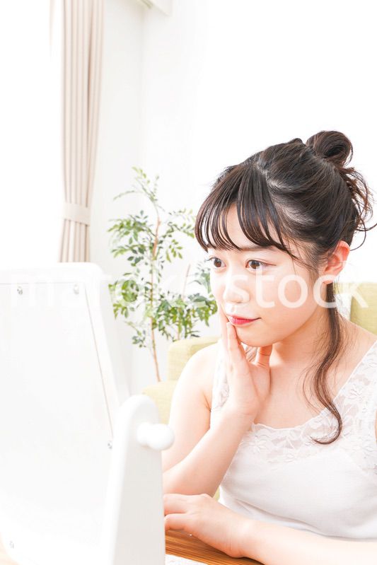スキンケア・メイクをする若い女性