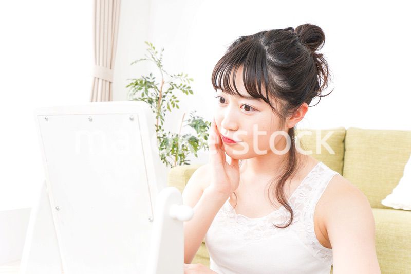 スキンケア・メイクをする若い女性