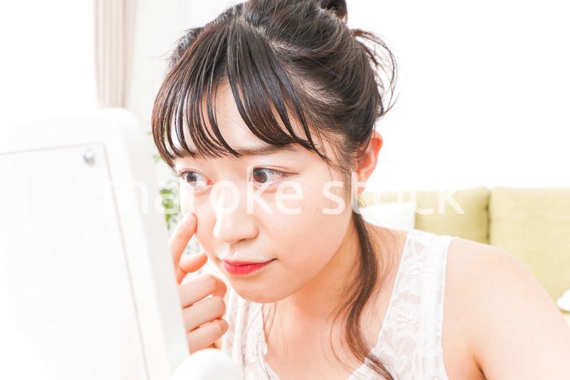 スキンケア・メイクをする若い女性