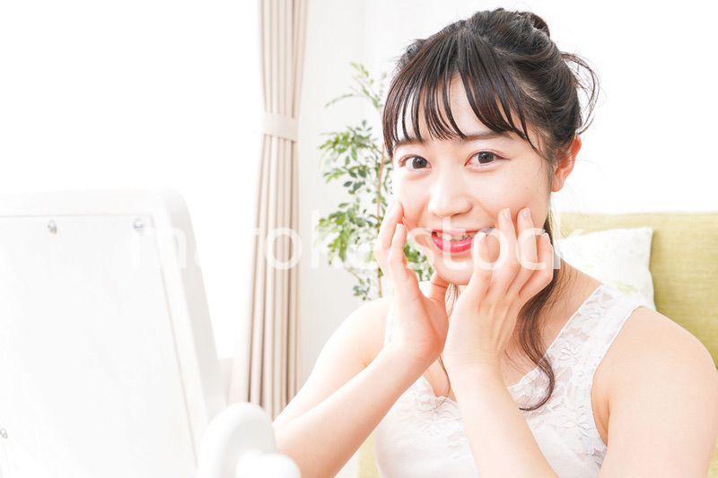 スキンケア・メイクをする若い女性