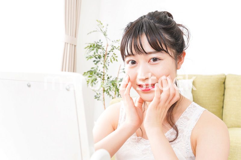 スキンケア・メイクをする若い女性