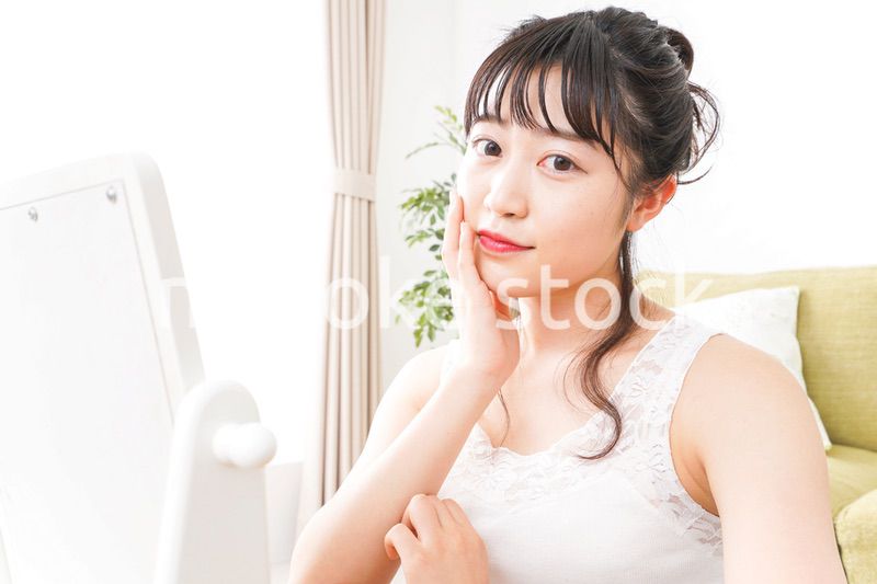 スキンケア・メイクをする若い女性