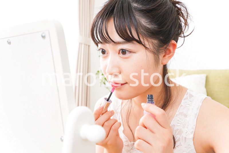 スキンケア・メイクをする若い女性