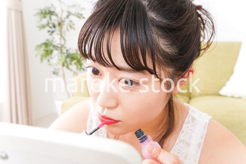 スキンケア・メイクをする若い女性