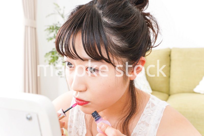 スキンケア・メイクをする若い女性