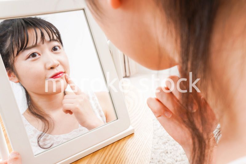 スキンケア・メイクをする若い女性