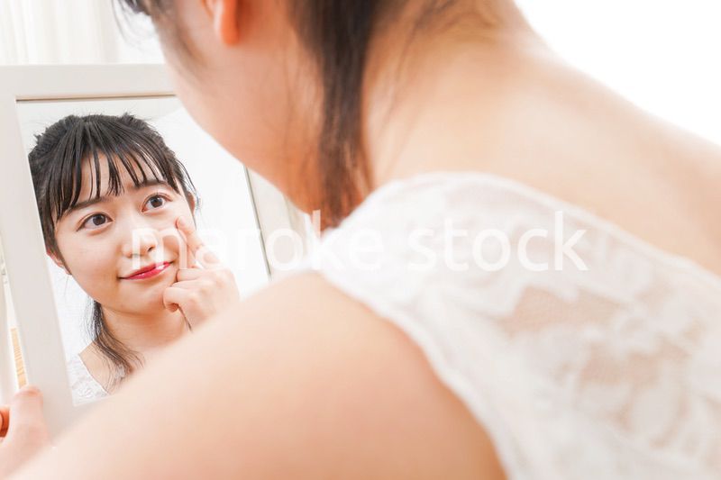 スキンケア・メイクをする若い女性