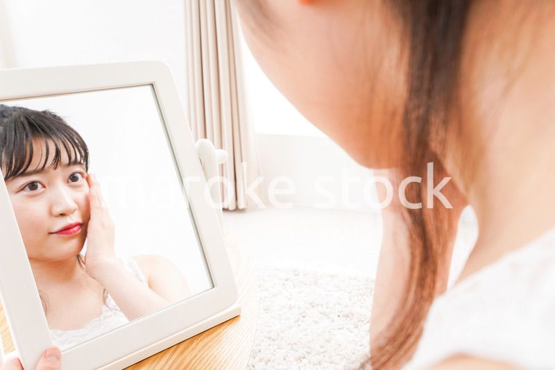 スキンケア・メイクをする若い女性