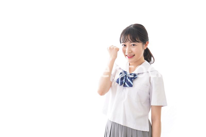 ガッツポーズをする制服姿の学生