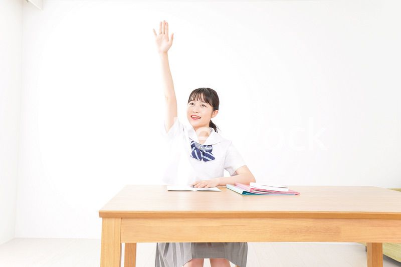 手を上げて発表をする学生