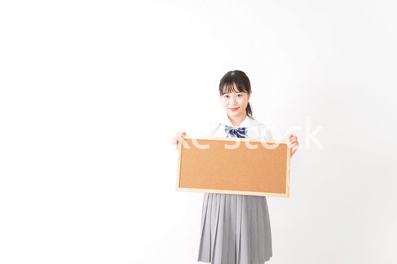 コルクボードを持つ学生