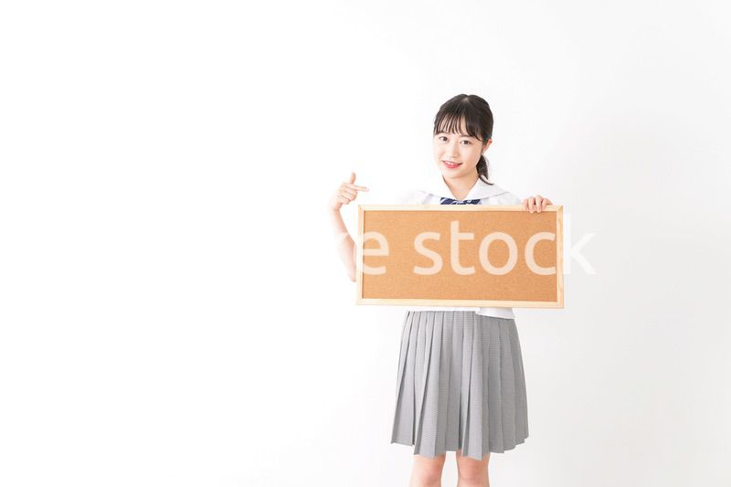 コルクボードを持つ学生