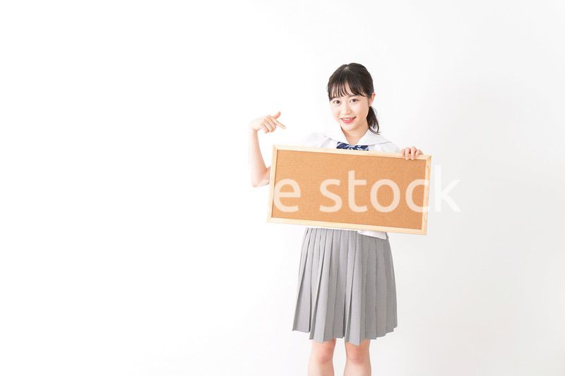 コルクボードを持つ学生