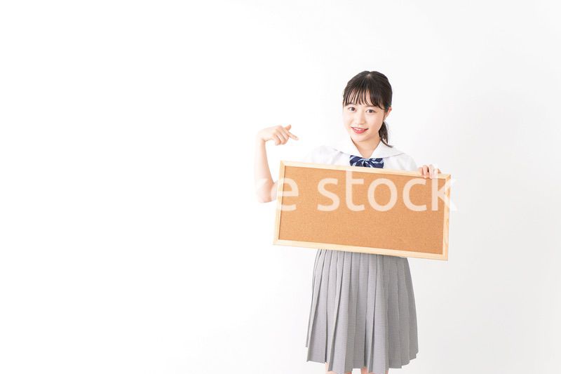 コルクボードを持つ学生