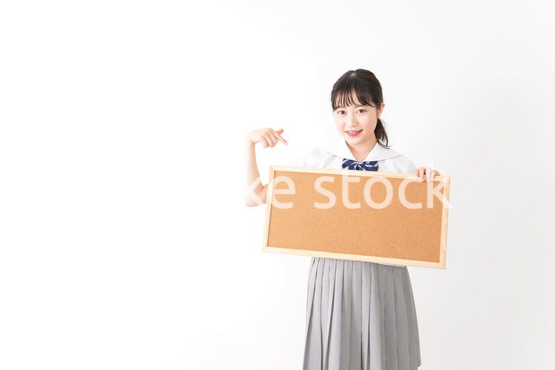 コルクボードを持つ学生